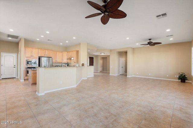 kitchen with light tile patterned floors, appliances with stainless steel finishes, light stone countertops, light brown cabinetry, and kitchen peninsula