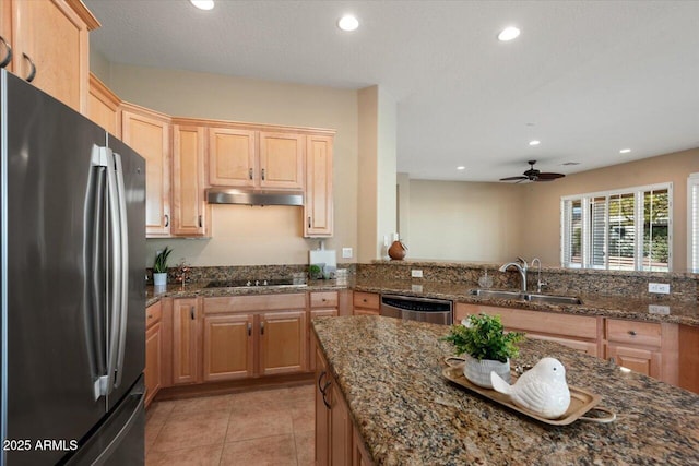 kitchen featuring sink, light tile patterned floors, appliances with stainless steel finishes, kitchen peninsula, and dark stone counters