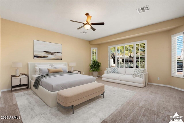 carpeted bedroom featuring multiple windows and ceiling fan