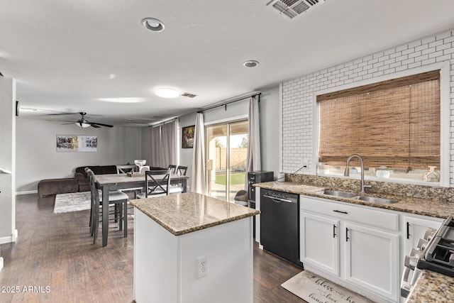 kitchen featuring stainless steel stove, white cabinetry, dishwasher, sink, and light stone countertops