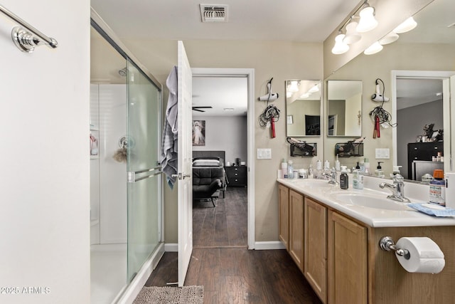 bathroom featuring hardwood / wood-style flooring, vanity, and a shower with shower door