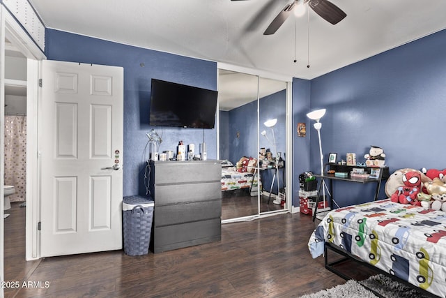 bedroom with dark hardwood / wood-style flooring, ceiling fan, and a closet