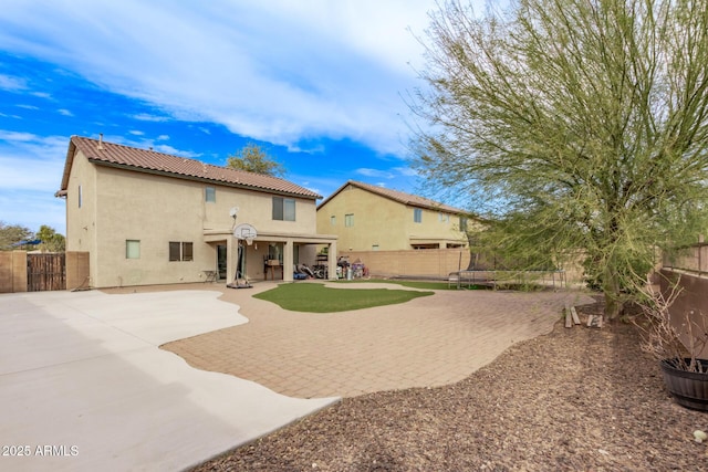 rear view of house with a patio area and a trampoline