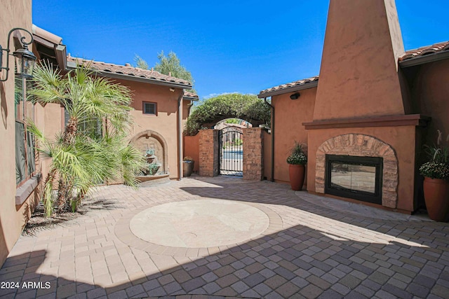 view of patio / terrace with a gate, fence, and exterior fireplace