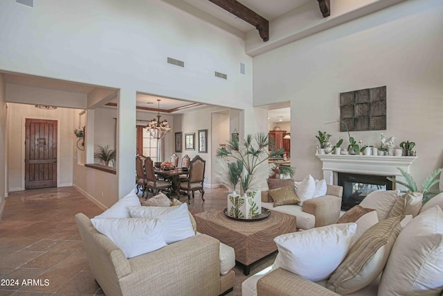 living area featuring baseboards, visible vents, beam ceiling, and an inviting chandelier