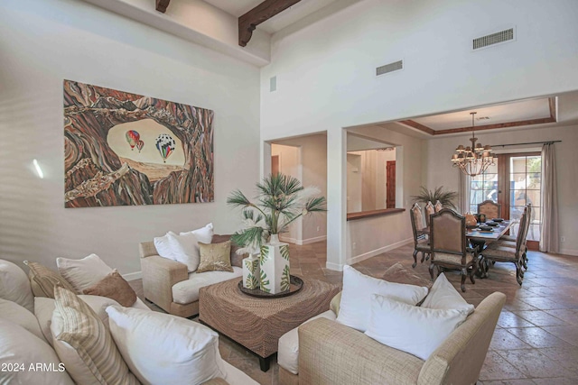 living area with baseboards, a chandelier, and visible vents