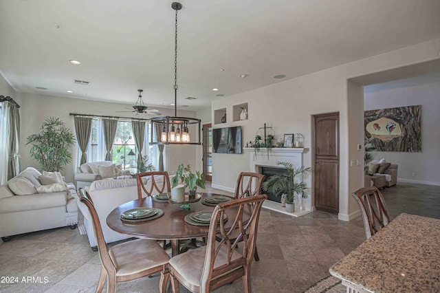 dining room featuring baseboards, a fireplace with raised hearth, recessed lighting, and a ceiling fan