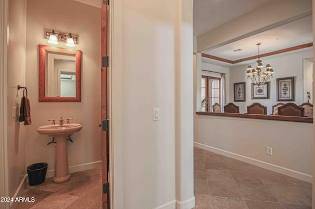 hallway featuring a notable chandelier and baseboards