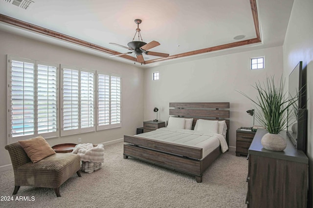bedroom featuring carpet flooring, a raised ceiling, baseboards, visible vents, and ceiling fan