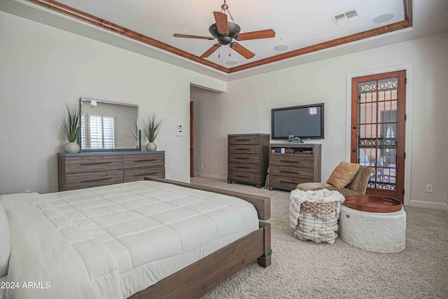 bedroom with carpet flooring, visible vents, baseboards, a ceiling fan, and a tray ceiling