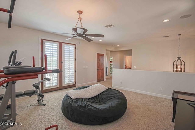 exercise area featuring ceiling fan with notable chandelier, carpet, baseboards, and visible vents
