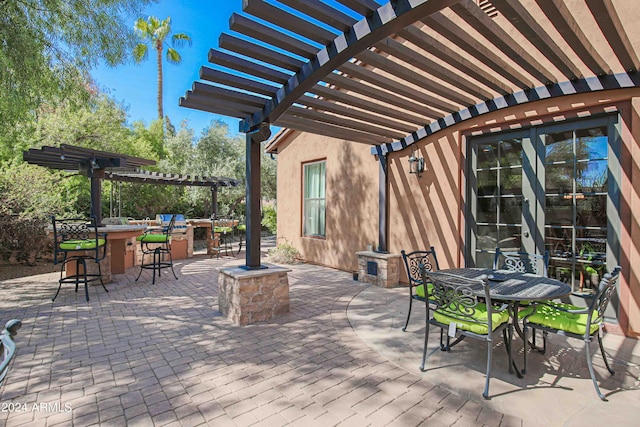 view of patio with a pergola, outdoor dining space, and outdoor dry bar