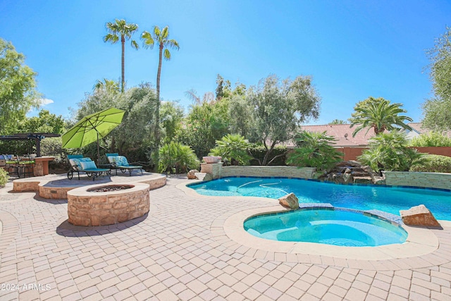 view of pool featuring an outdoor fire pit, a pool with connected hot tub, and a patio