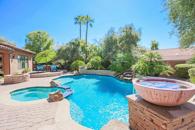 view of swimming pool featuring a patio and a pool with connected hot tub