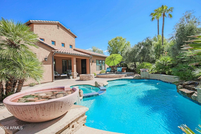 view of pool with outdoor dining space, a pool with connected hot tub, and a patio area