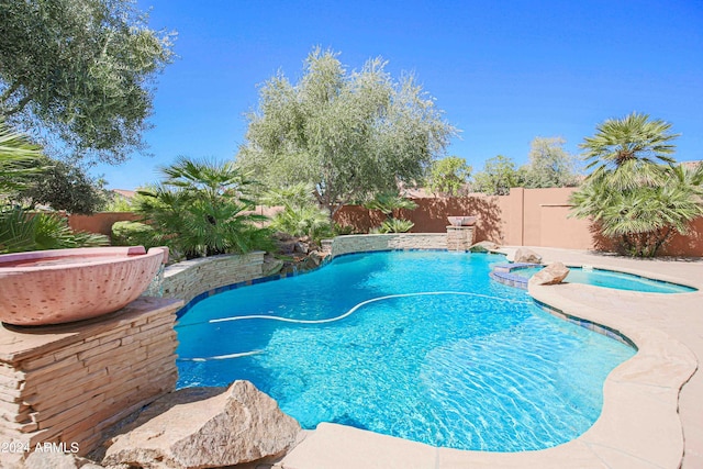view of pool featuring a fenced backyard, a fenced in pool, and an in ground hot tub