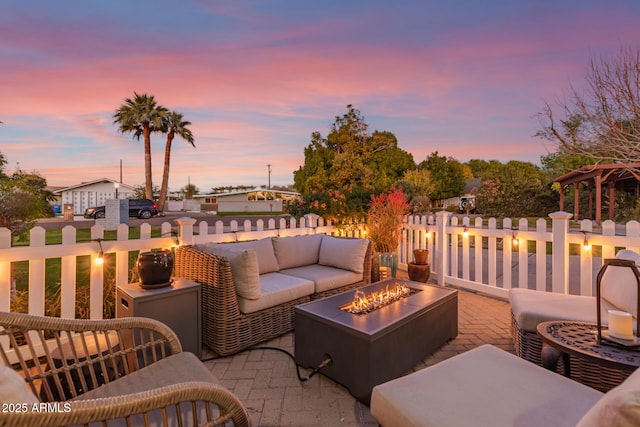 patio terrace at dusk with an outdoor living space with a fire pit