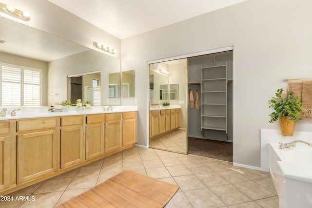 bathroom featuring tile patterned flooring, vanity, and a bath