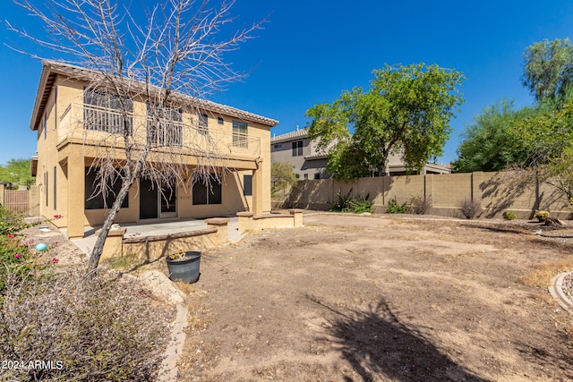 back of house with a balcony and a patio area