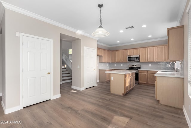 kitchen featuring a center island, sink, hanging light fixtures, ornamental molding, and stainless steel appliances