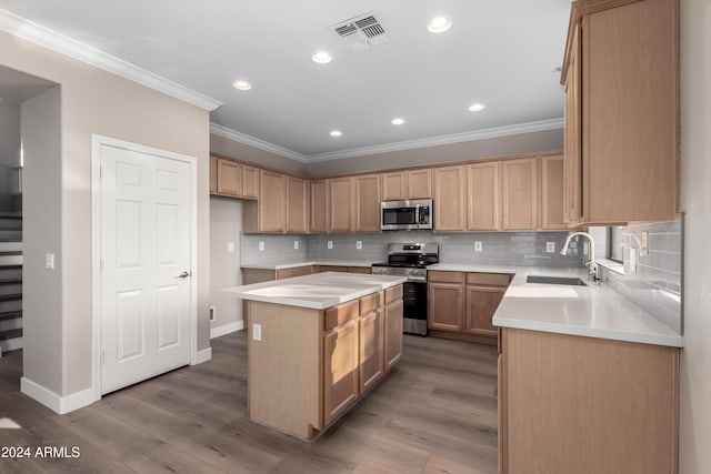 kitchen featuring a center island, sink, stainless steel appliances, crown molding, and wood-type flooring