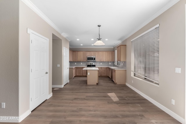 kitchen featuring appliances with stainless steel finishes, hanging light fixtures, ornamental molding, and sink