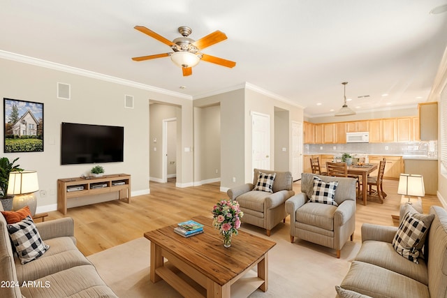 living room featuring ceiling fan, light wood-type flooring, and ornamental molding