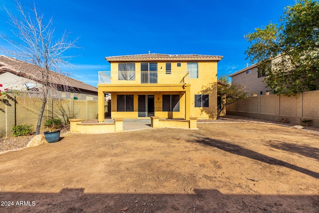 back of property with a balcony and a patio