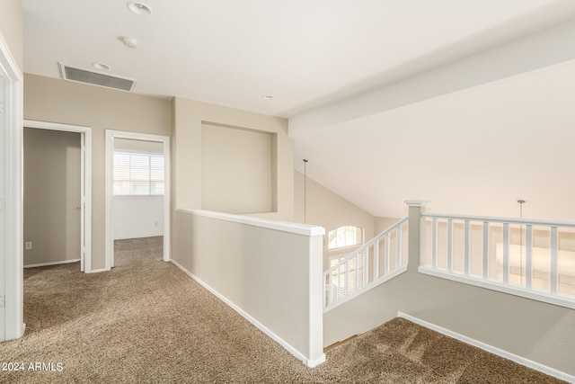 corridor with lofted ceiling and carpet floors