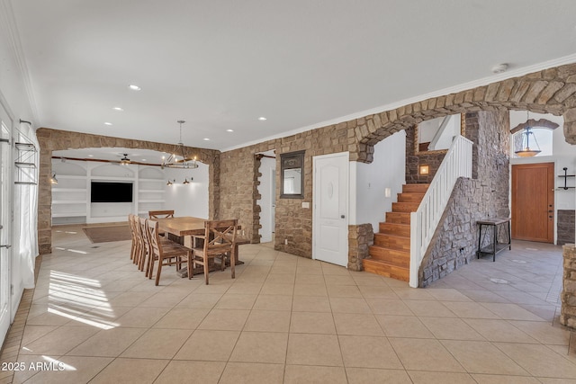 unfurnished dining area featuring stairway, light tile patterned flooring, arched walkways, and ornamental molding