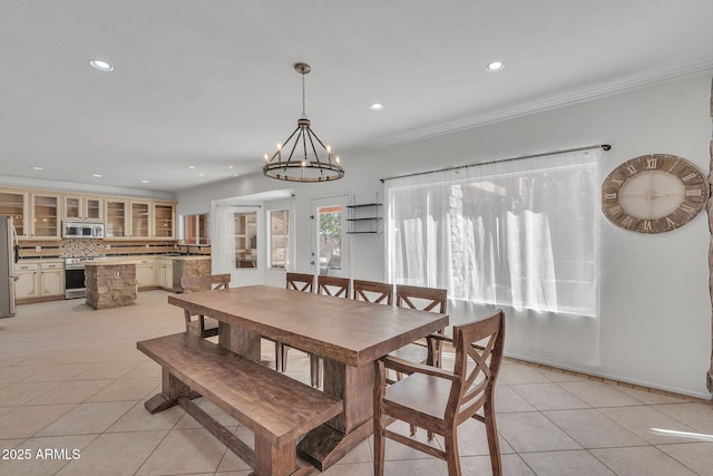 dining area with recessed lighting, light tile patterned flooring, an inviting chandelier, and crown molding