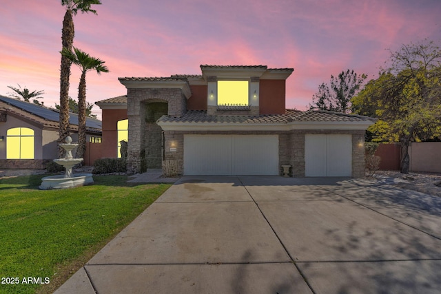 mediterranean / spanish home featuring driveway, stone siding, a tile roof, and stucco siding