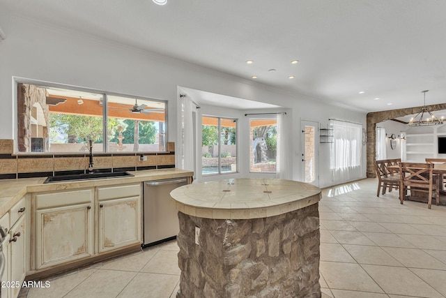 kitchen featuring tile counters, a sink, dishwasher, and light tile patterned floors