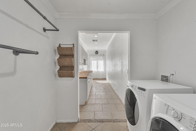 clothes washing area with light tile patterned floors, visible vents, ornamental molding, separate washer and dryer, and laundry area