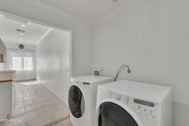 laundry area featuring light tile patterned floors, washing machine and dryer, laundry area, visible vents, and crown molding