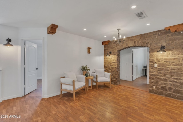 sitting room featuring visible vents, arched walkways, wood finished floors, an inviting chandelier, and recessed lighting