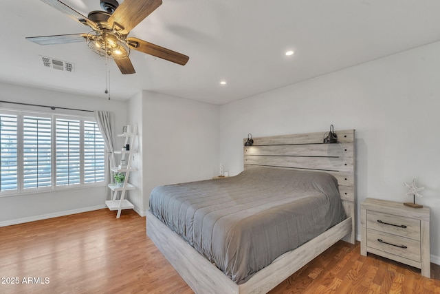 bedroom with recessed lighting, wood finished floors, visible vents, and baseboards