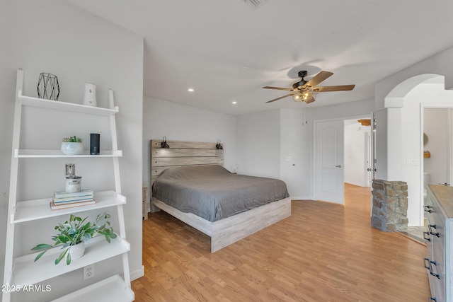 bedroom featuring arched walkways, ceiling fan, light wood-style flooring, and recessed lighting