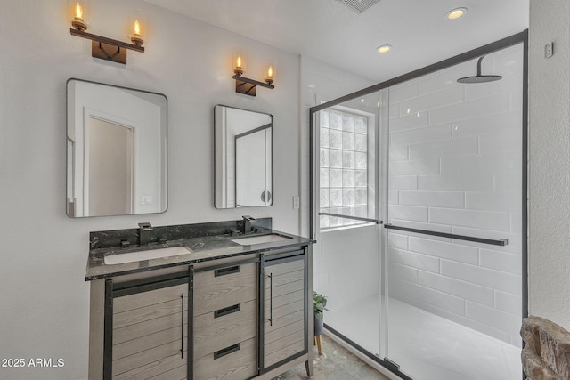 bathroom with double vanity, a shower stall, a sink, and recessed lighting