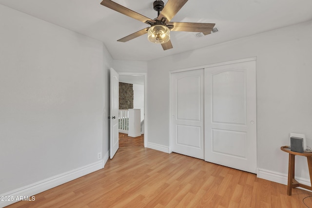 unfurnished bedroom with light wood-type flooring, a closet, visible vents, and baseboards