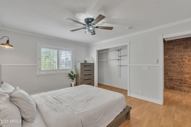 bedroom featuring light wood finished floors, baseboards, a ceiling fan, brick wall, and ornamental molding