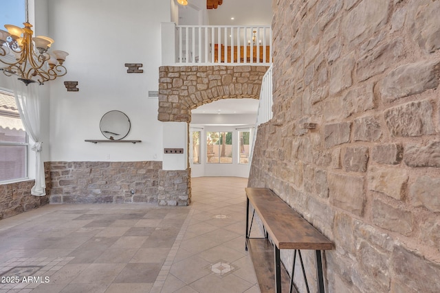 foyer featuring a notable chandelier, a high ceiling, and light tile patterned floors