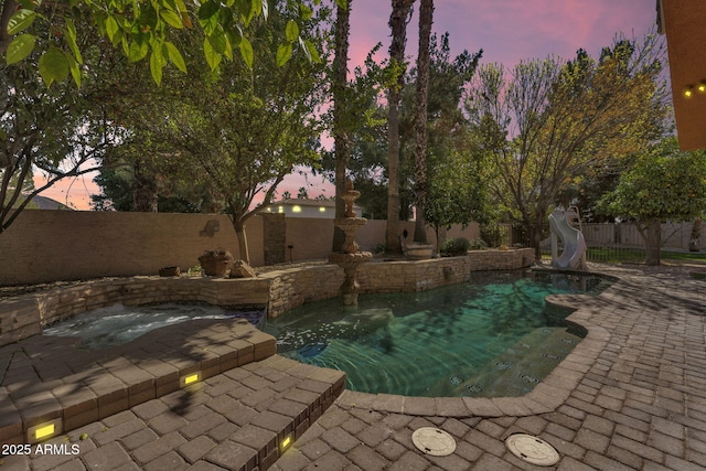 view of swimming pool featuring a patio area, a fenced backyard, a fenced in pool, and a water slide