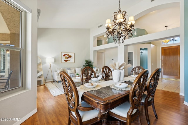 dining space with hardwood / wood-style flooring and a notable chandelier