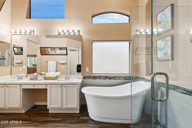 bathroom with a bathing tub, vanity, tile walls, and hardwood / wood-style floors