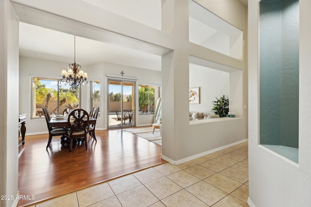 tiled dining area with a wealth of natural light and a notable chandelier