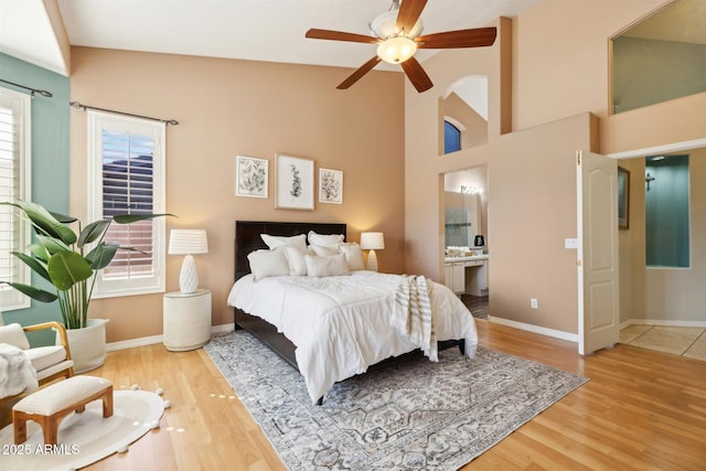 bedroom with hardwood / wood-style floors, ensuite bathroom, ceiling fan, and lofted ceiling