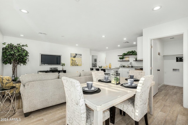 dining room featuring sink and light hardwood / wood-style flooring