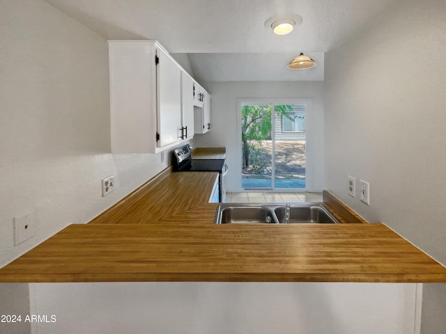 kitchen featuring electric stove, white cabinetry, and sink