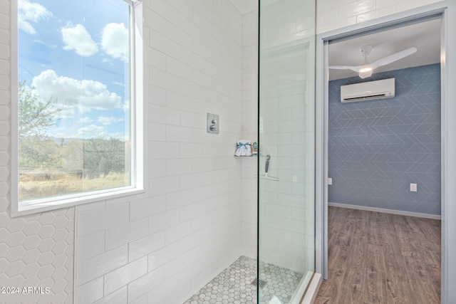 bathroom with wood-type flooring, ceiling fan, walk in shower, and a wall mounted AC